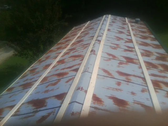 Rusted metal roof panels with new wood purlins before replacement — Storm Damage Roof Repair in Ferdinand by Roofing Brothers